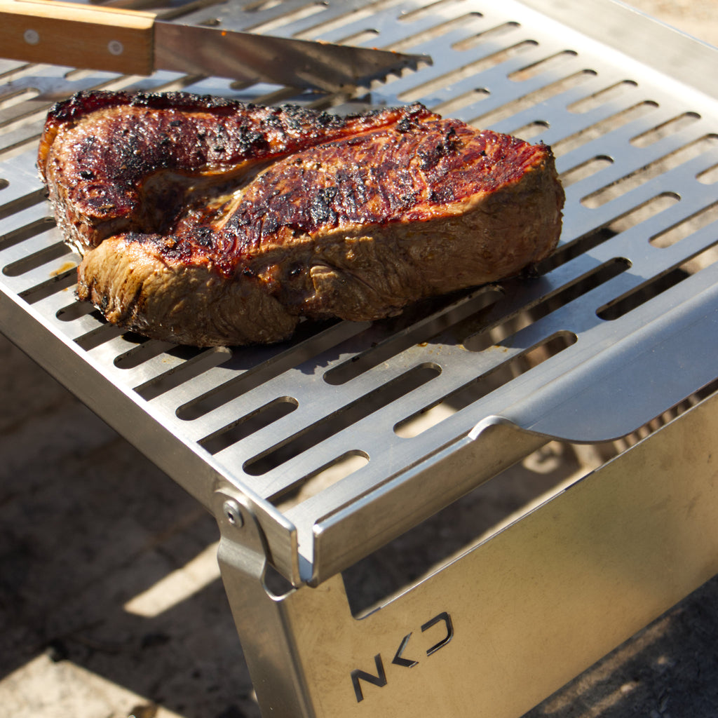 Grilled steak on a portable grid.